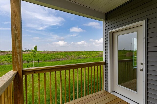 wooden deck with a lawn and a rural view