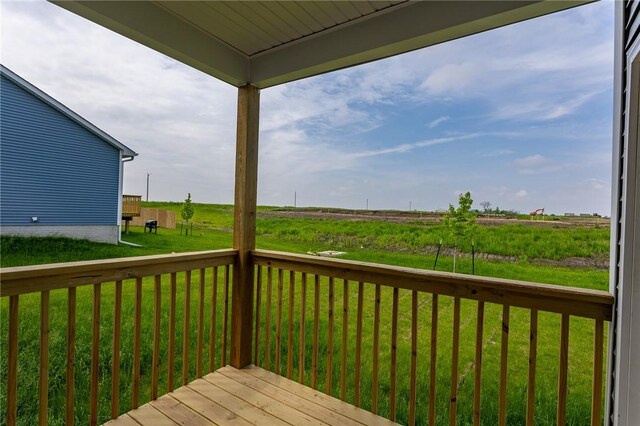 wooden deck with a yard and a rural view