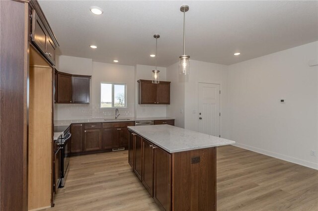 kitchen featuring a center island, hanging light fixtures, decorative backsplash, dark brown cabinetry, and stainless steel appliances