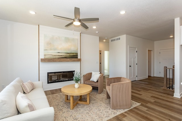 985 11th St, Waukee, IA 50263 - living area with recessed lighting, ceiling fan, visible vents, light wood-style floors, and a large fireplace