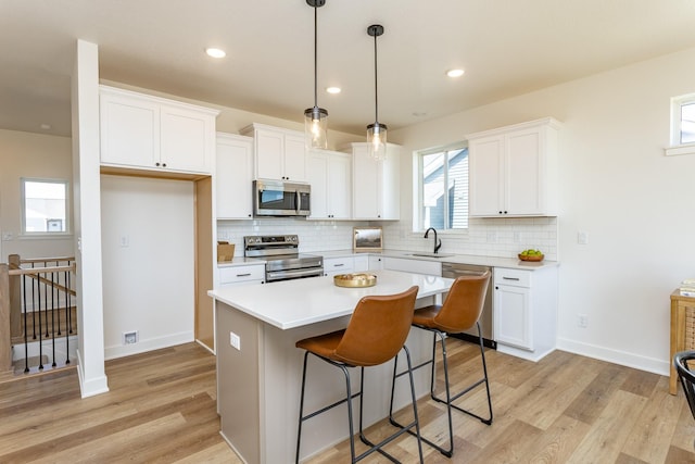 985 11th St, Waukee, IA 50263 - kitchen featuring white cabinetry, light wood-style floors, appliances with stainless steel finishes, and a sink