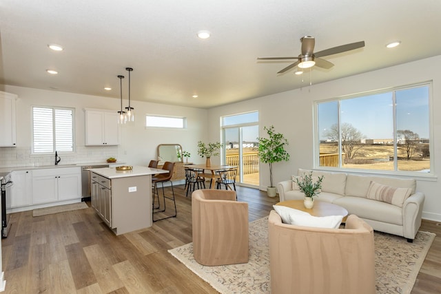 985 11th St, Waukee, IA 50263 - kitchen featuring recessed lighting, ceiling fan, a center island, and a kitchen bar