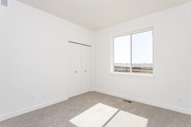 985 11th St, Waukee, IA 50263 - unfurnished bedroom with baseboards, a closet, visible vents, and carpet floors