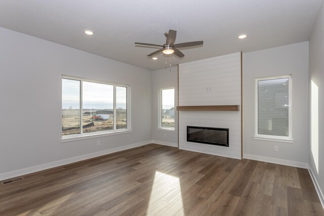 1060 Gray Ave, Waukee, IA 50263 - unfurnished living room with wood finished floors, a large fireplace, baseboards, visible vents, and ceiling fan