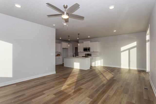 1060 Gray Ave, Waukee, IA 50263 - unfurnished living room featuring baseboards, ceiling fan, wood finished floors, and recessed lighting