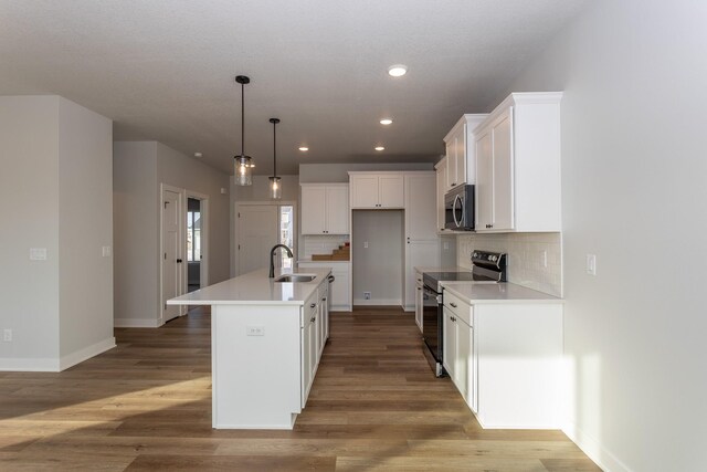 1060 Gray Ave, Waukee, IA 50263 - kitchen with white cabinetry, light wood-style flooring, a sink, and stainless steel appliances