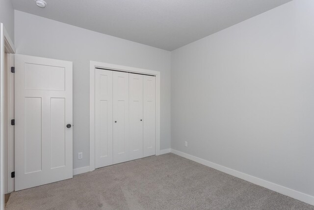 1060 Gray Ave, Waukee, IA 50263 - unfurnished bedroom featuring carpet flooring, a closet, and baseboards