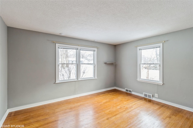 spare room featuring hardwood / wood-style floors and a textured ceiling