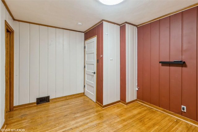 unfurnished bedroom with ornamental molding and light hardwood / wood-style flooring