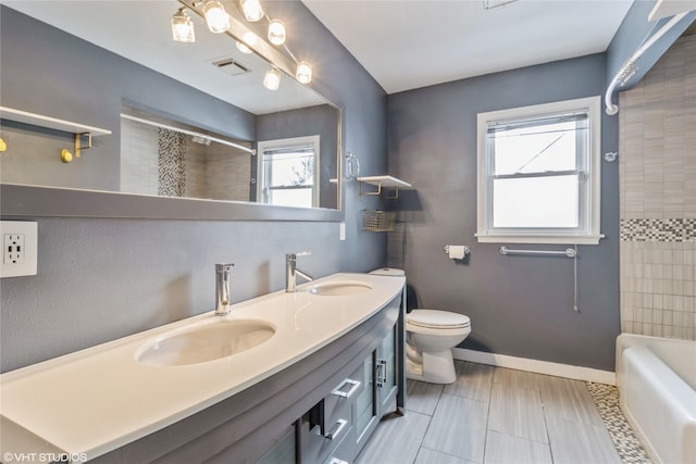 full bathroom featuring vanity, tiled shower / bath combo, and toilet