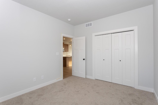 unfurnished bedroom with carpet floors, visible vents, and baseboards