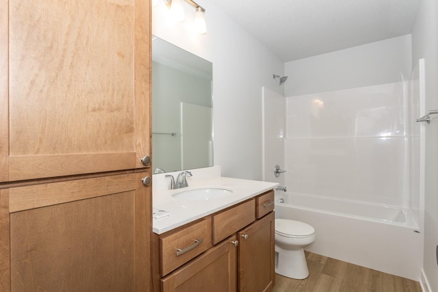 full bath with shower / bathtub combination, vanity, wood finished floors, and toilet