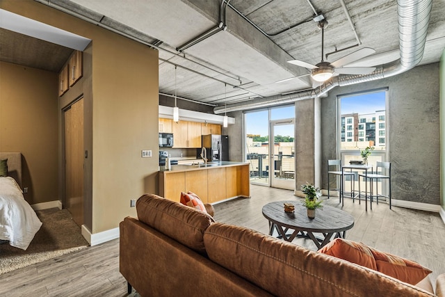 living room with ceiling fan and light wood-type flooring