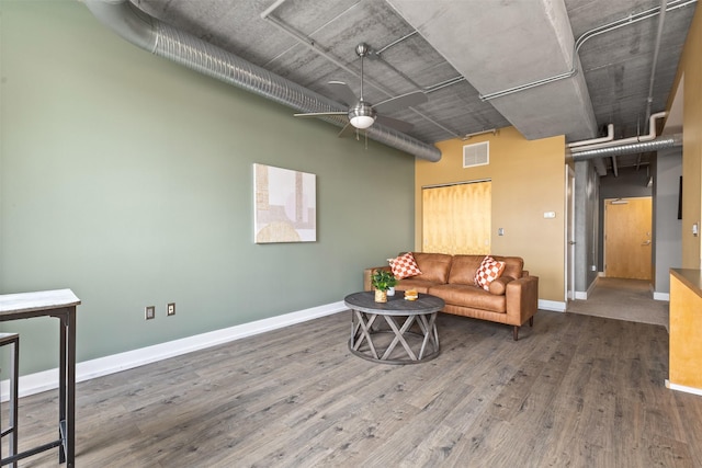 living room with a high ceiling, dark hardwood / wood-style floors, and ceiling fan