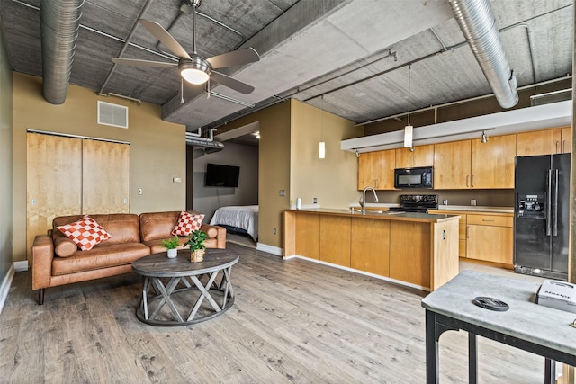 kitchen with kitchen peninsula, light wood-type flooring, sink, and black appliances