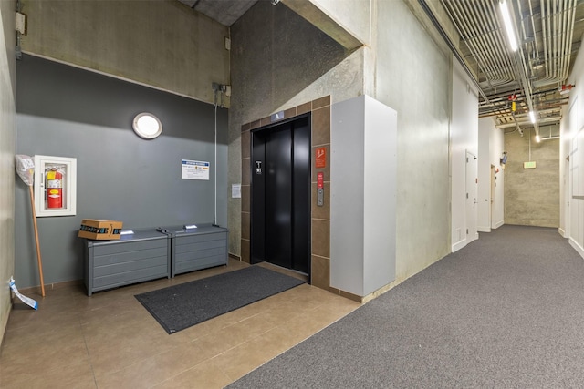 hallway featuring a towering ceiling and elevator