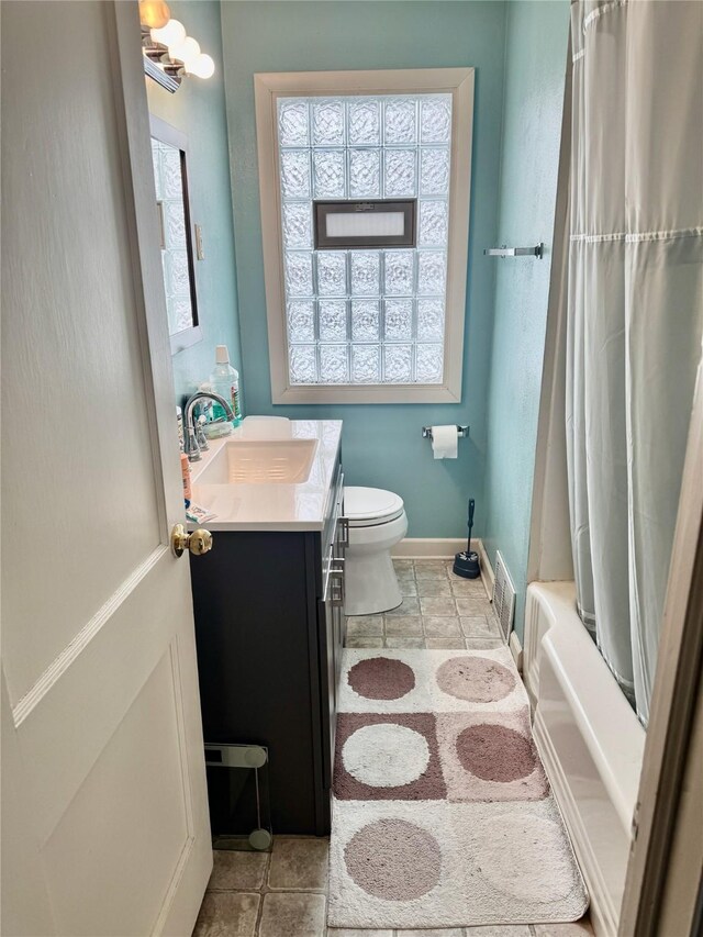 full bathroom with vanity, tile patterned floors, toilet, and shower / tub combo with curtain