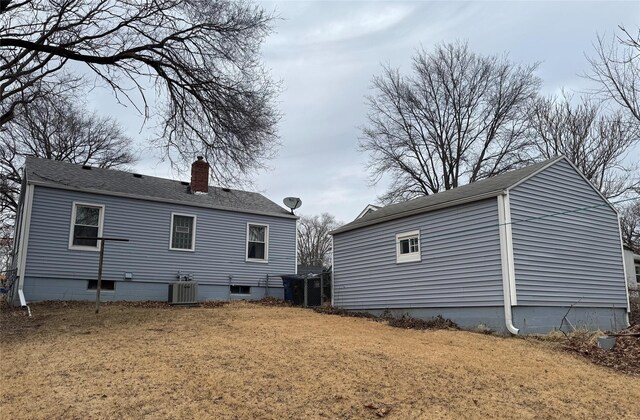 back of house with cooling unit and a yard