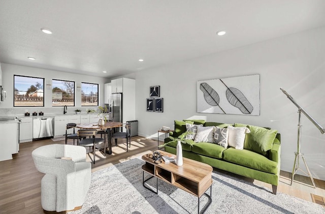 living area with baseboards, wood finished floors, and recessed lighting