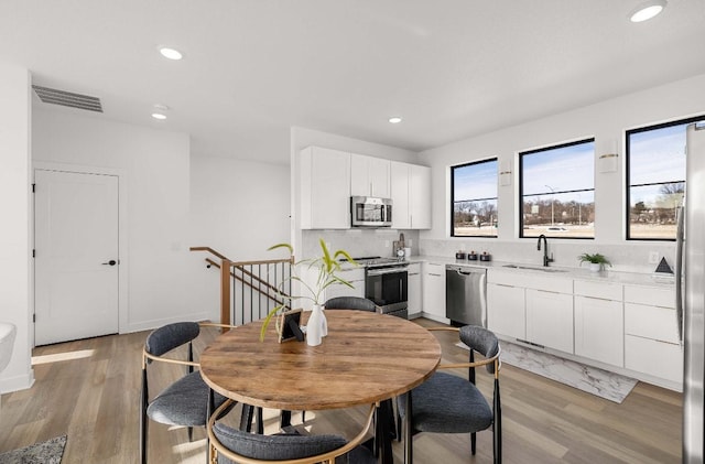 dining area featuring light wood-type flooring, visible vents, and recessed lighting