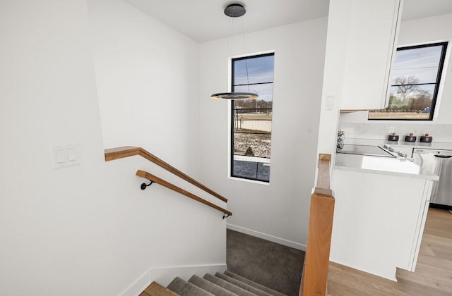 staircase featuring baseboards and wood finished floors