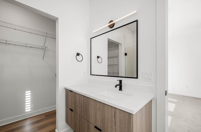 bathroom featuring wood finished floors, vanity, and baseboards