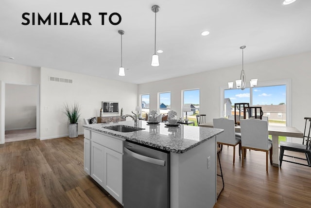 kitchen featuring stainless steel dishwasher, a center island with sink, light stone countertops, and sink