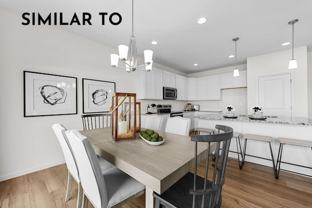 dining space with light hardwood / wood-style flooring and a chandelier