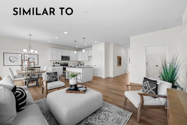 living room with a notable chandelier and light hardwood / wood-style flooring