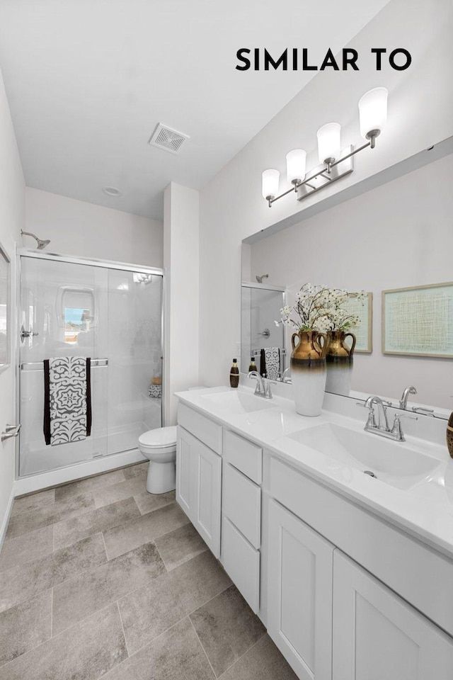 bathroom featuring vanity, toilet, and an enclosed shower