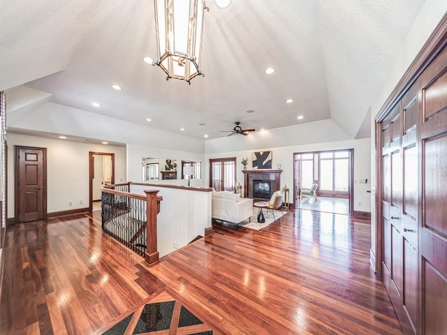 living room featuring dark hardwood / wood-style flooring, a textured ceiling, and vaulted ceiling