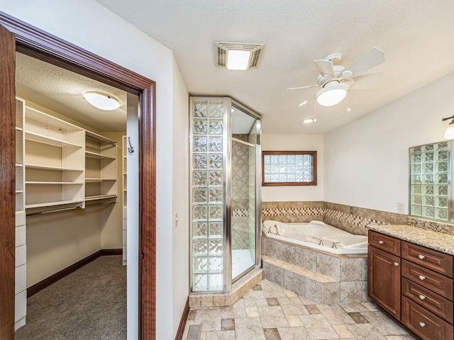 bathroom featuring ceiling fan, vanity, and shower with separate bathtub