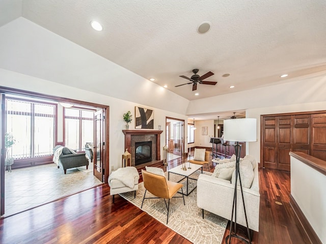 living room featuring a wealth of natural light, ceiling fan, dark hardwood / wood-style flooring, and a textured ceiling