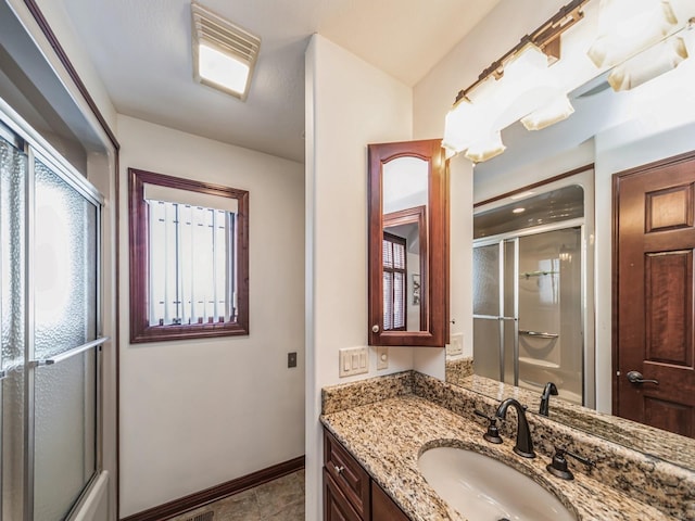 bathroom featuring tile patterned flooring, vanity, and a shower with door