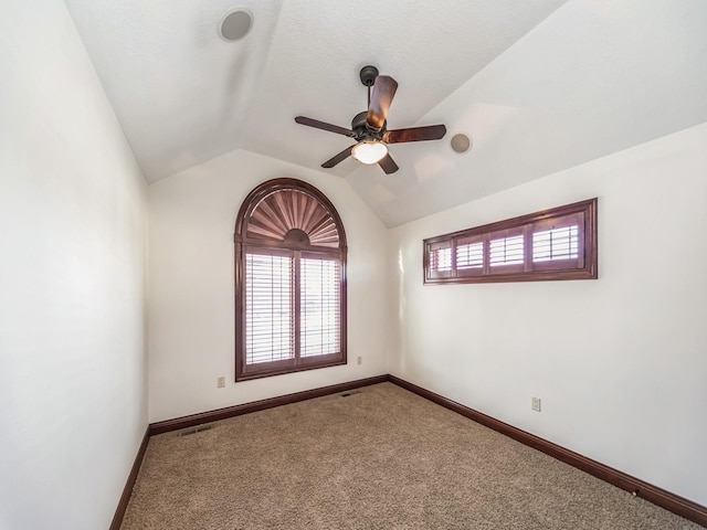 unfurnished room featuring carpet flooring, vaulted ceiling, and ceiling fan