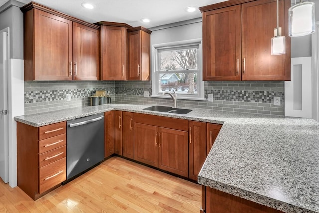 kitchen featuring backsplash, pendant lighting, sink, and stainless steel dishwasher