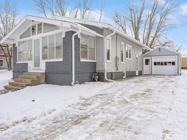 view of snow covered exterior with an outbuilding and a garage