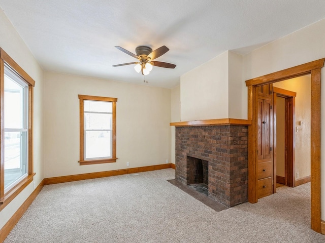 unfurnished living room with light carpet, a brick fireplace, and ceiling fan