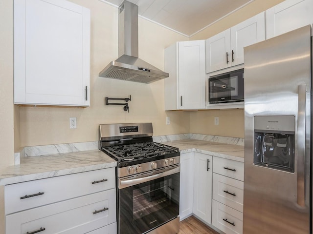 kitchen featuring white cabinetry, wall chimney exhaust hood, light stone counters, and appliances with stainless steel finishes