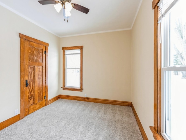 carpeted empty room featuring ceiling fan and crown molding