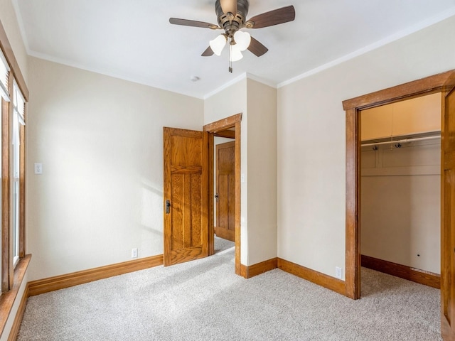 unfurnished bedroom with a closet, crown molding, ceiling fan, and light colored carpet