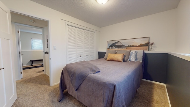 carpeted bedroom with a textured ceiling and a closet