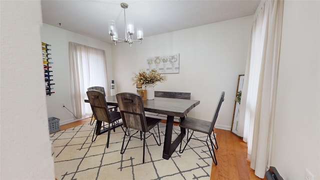 dining space with a chandelier and light hardwood / wood-style floors