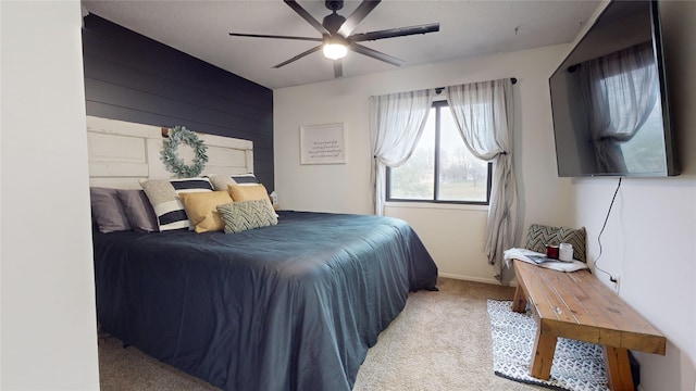 carpeted bedroom featuring ceiling fan and wooden walls