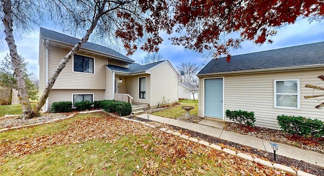 view of front of property featuring roof with shingles and a front lawn