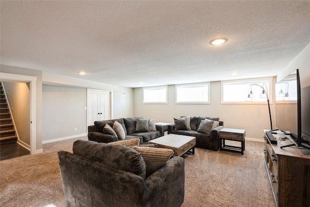 carpeted living room featuring a textured ceiling