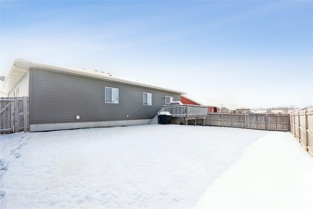 snow covered house with a wooden deck