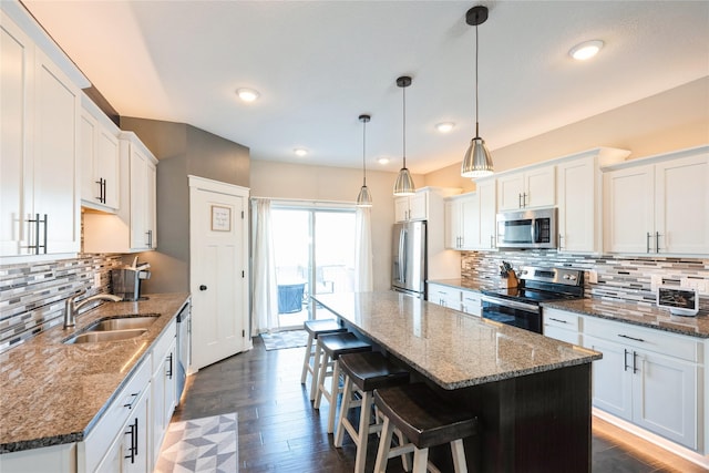 kitchen featuring sink, white cabinetry, appliances with stainless steel finishes, and hanging light fixtures