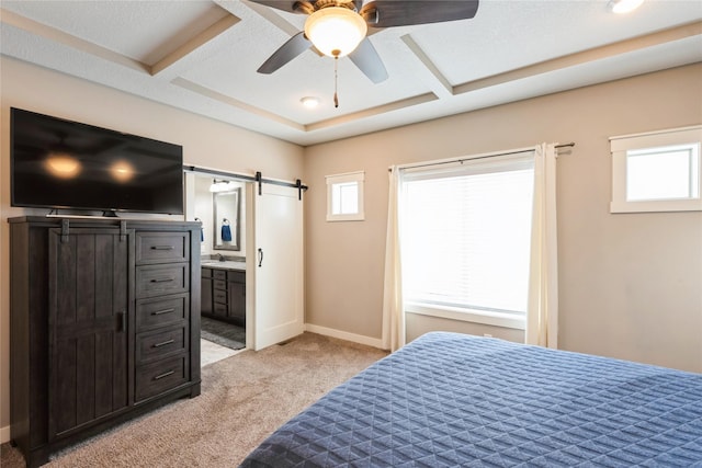 carpeted bedroom featuring ensuite bathroom, ceiling fan, and a barn door