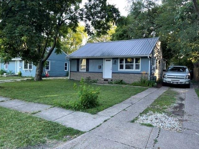 single story home featuring a front lawn